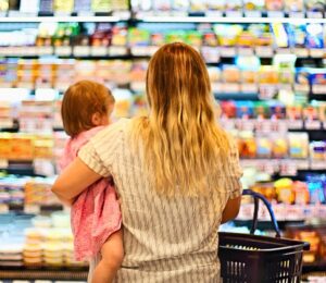 Photo shows a mother holding a baby and grocery store shopping. Over 80 percent of food for toddlers sold at US grocery stores in Austin, Texas is ultra-processed, according to a new audit