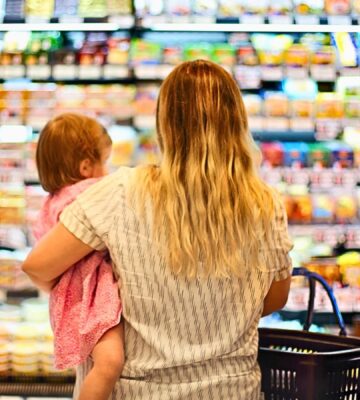 Photo shows a mother holding a baby and grocery store shopping. Over 80 percent of food for toddlers sold at US grocery stores in Austin, Texas is ultra-processed, according to a new audit