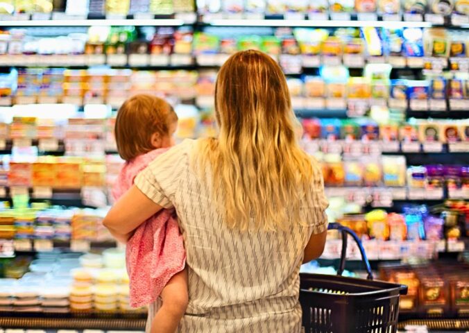 Photo shows a mother holding a baby and grocery store shopping. Over 80 percent of food for toddlers sold at US grocery stores in Austin, Texas is ultra-processed, according to a new audit