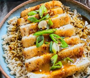 tofu katsu curry with brown rice, carrot and onion curry, and a panko-covered piece of tofu for plant-based meals that keep you full