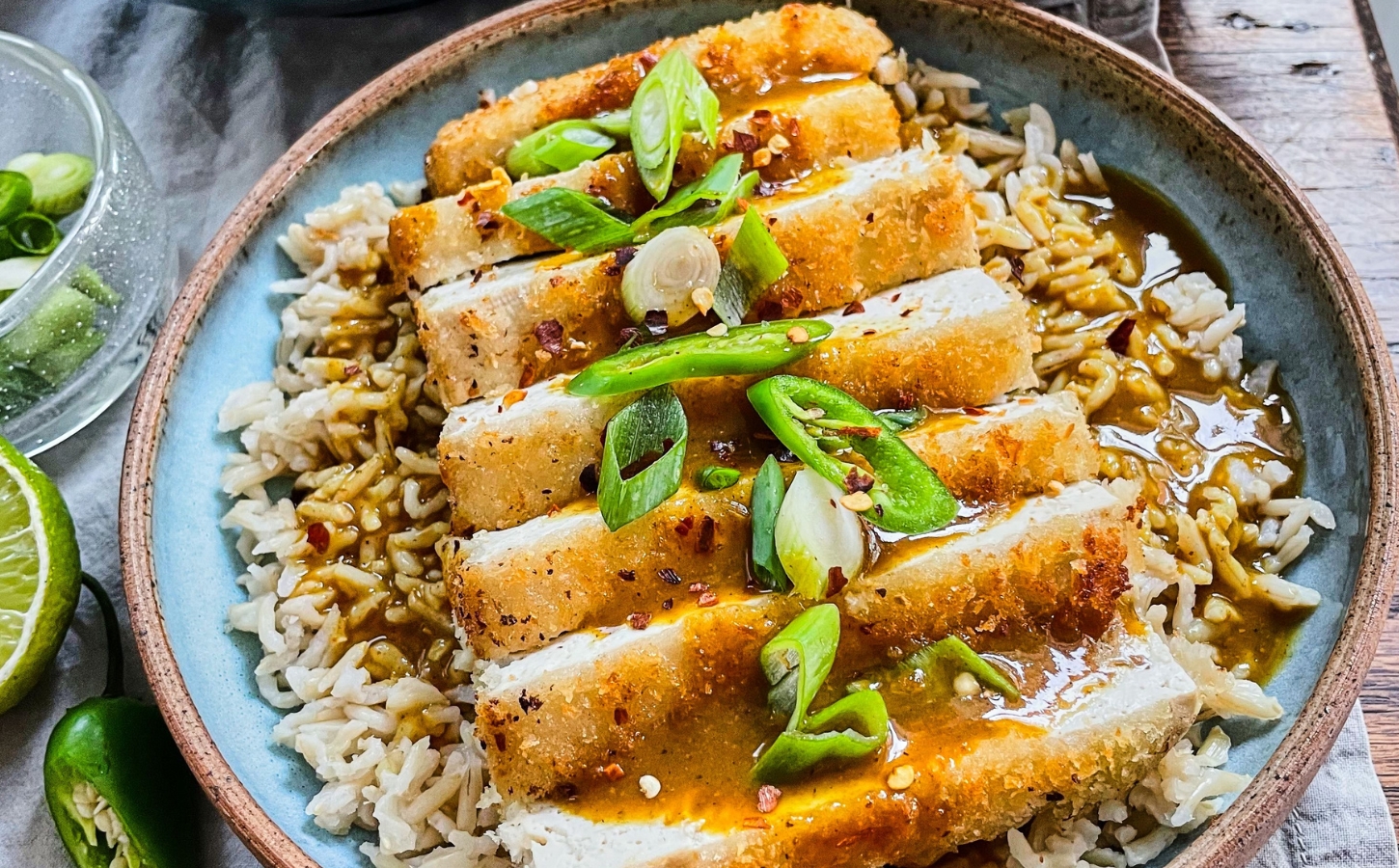 tofu katsu curry with brown rice, carrot and onion curry, and a panko-covered piece of tofu for plant-based meals that keep you full