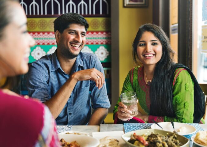 Photo shows an Indian couple eating with friends at a cafe or restaurant. New research has found that nearly 60 percent of young Indians are already “meat-reducers,” while 50 percent of those who self-identify as omnivores are open to the idea of veganism.