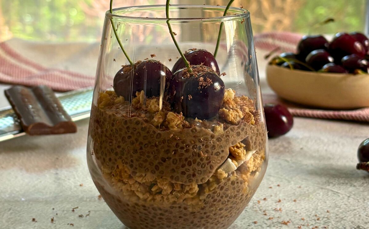 a glass of cherry chia pudding with granola