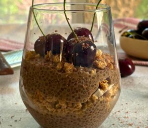 a glass of cherry chia pudding with granola