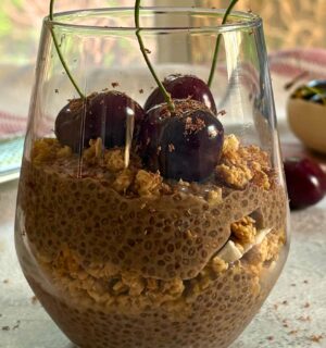 a glass of cherry chia pudding with granola
