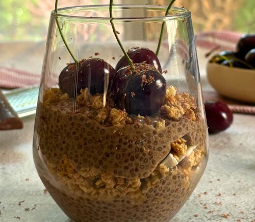 a glass of cherry chia pudding with granola