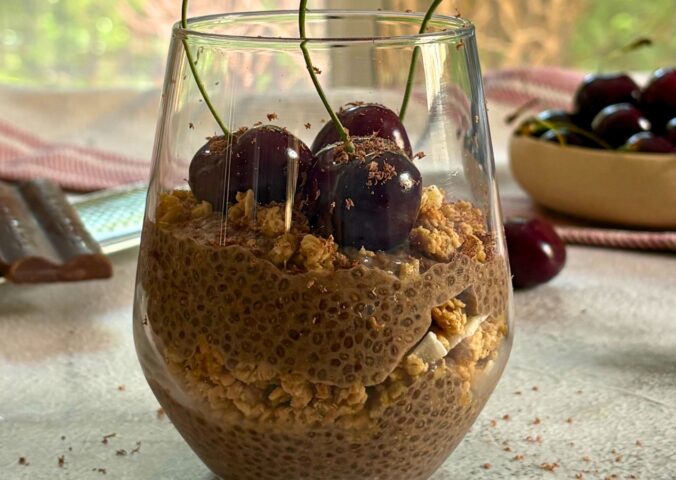 a glass of cherry chia pudding with granola