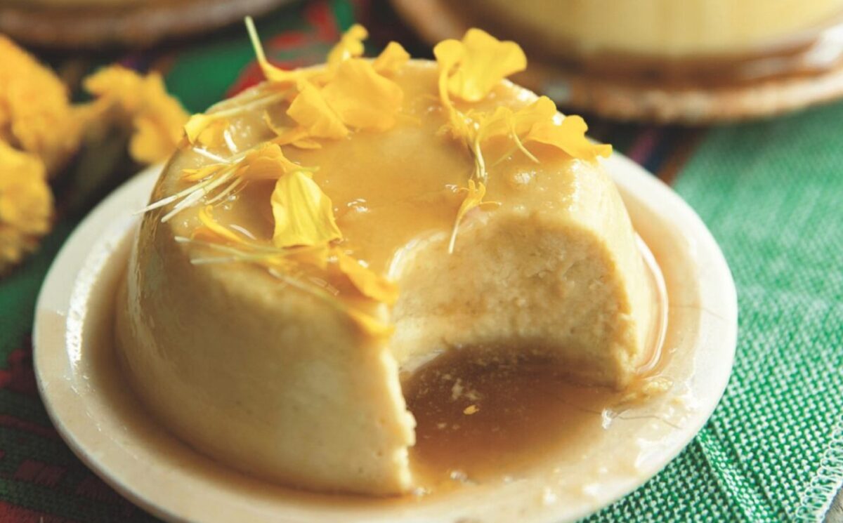 a picture of a vegan coconut flan made with tofu, coconut milk and cream, agar powder, sugar, vanilla, and topped with a syrup and edible flowers for vegan coconut recipes