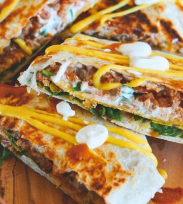 crunchy tostada wrap with corn tortilla, lentils, refired beans, vegan cheese sauce, cashew sour cream and more