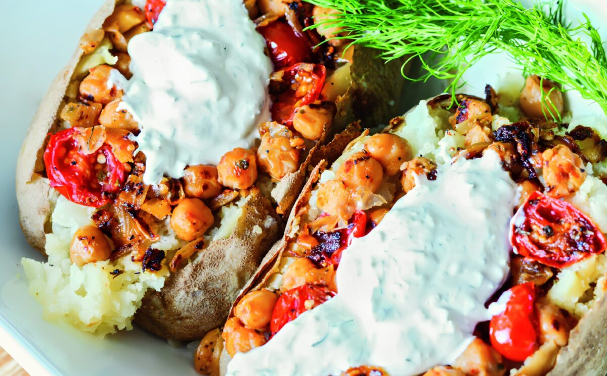 Greek-Seasoned Loaded Baked Potatoes with chickpeas, vegan sour cream, lemon, cucumber, garlic, and tomato