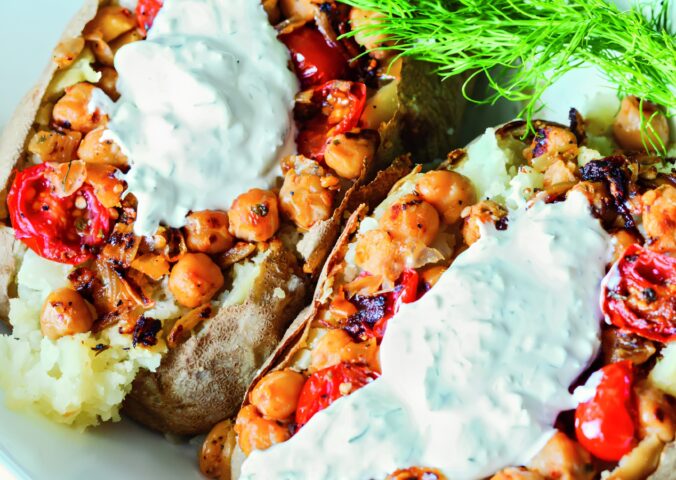 Greek-Seasoned Loaded Baked Potatoes with chickpeas, vegan sour cream, lemon, cucumber, garlic, and tomato