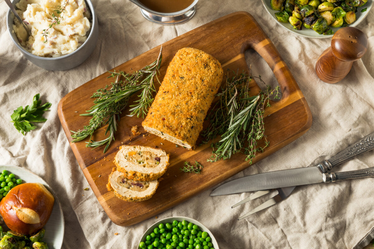 Photo shows a homemade vegan centerpiece for Thanksgiving, Christmas, or another holiday, on a wooden board surrounded by meat-free sides and vegetables. Nostalgia is a “major barrier” to dietary changes, including widespread adoption of plant-based diets, according to new research