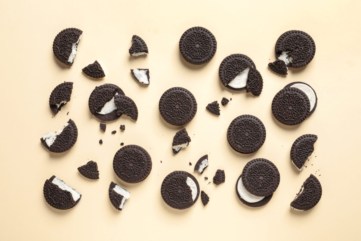 Photo shows a selection of intact and broken Oreo cookies on a pale yellow background. Oreo has announced three new, limited edition flavors: Chicken & Waffles, Deep Fried, and Banana Pudding