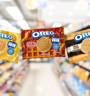 Photo shows the packaging of the three new flavors of Oreo cookies against a stock supermarket image background. The Oreo flavors include Banana Pudding (left), Chicken And Waffles (center), and Deep Fried (right).