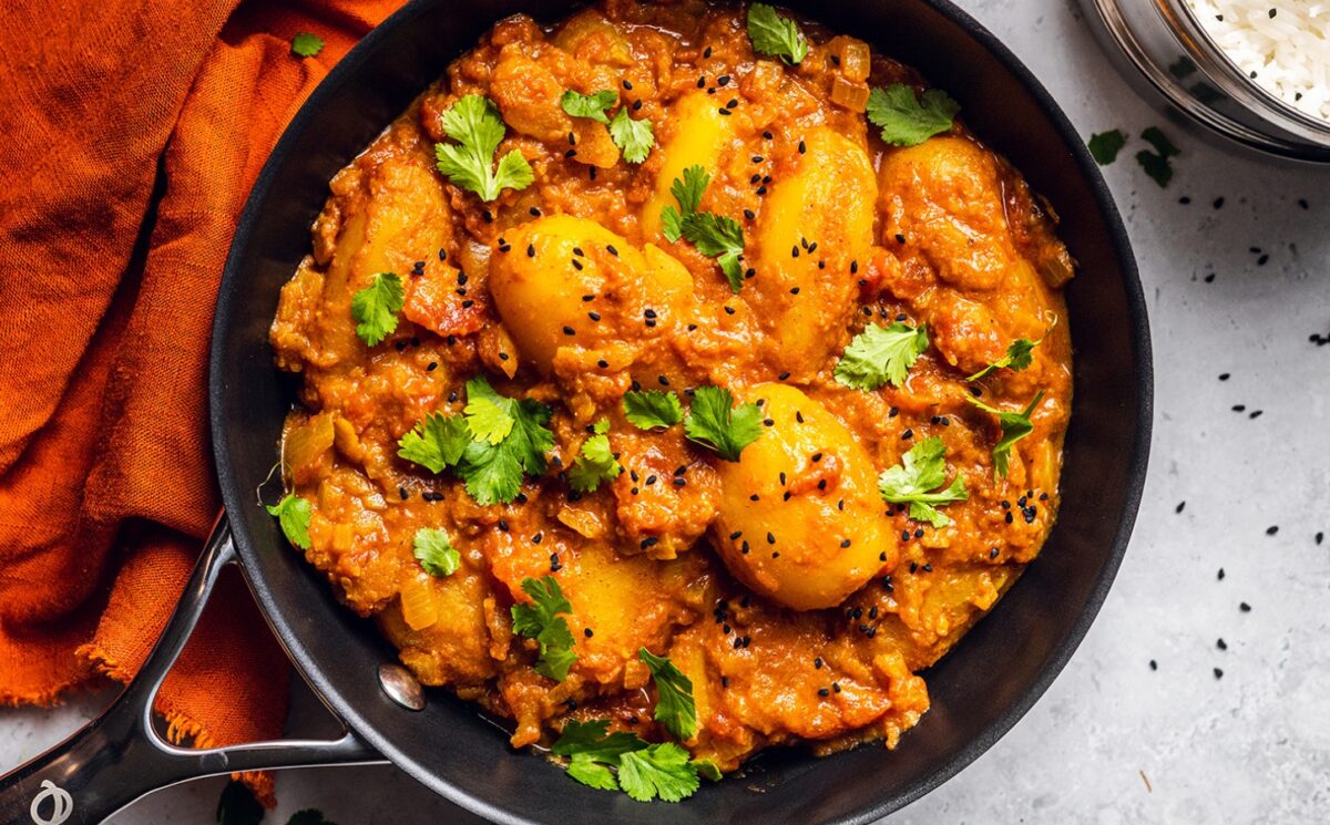 Vegan Dum Aloo with baby potatoes, tomato gravy, fresh spices, and turmeric for basic vegan meals