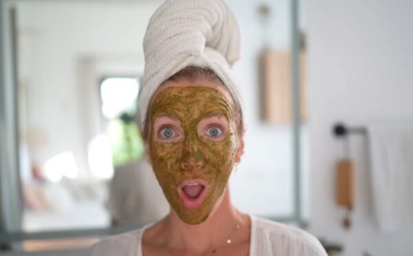 Image of Stanczyk with her hair wrapped in a white towel and her face covered in her matcha glow mask to illustrate article about DIY Plant-based spa treatments.