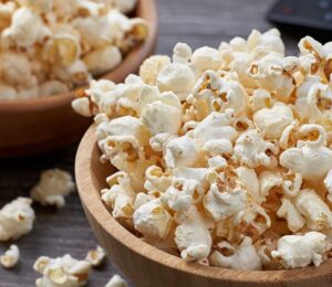 Two wooden bowls overflowing with freshly popped popcorn, highlighting the benefits of air-popped popcorn as a whole-grain snack
