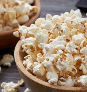 Two wooden bowls overflowing with freshly popped popcorn, highlighting the benefits of air-popped popcorn as a whole-grain snack