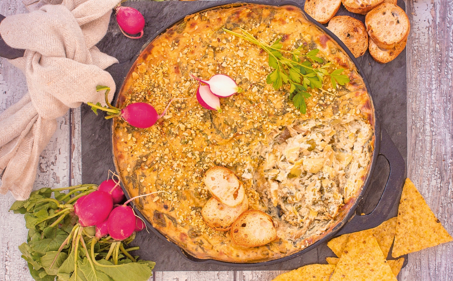 Baked Spinach And Artichoke Dip with tofu, garlic, vegan cream cheese, and brazil nut parm