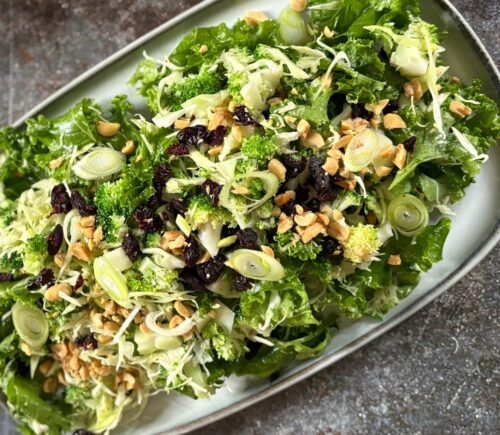 broccoli salad with kale, cabbage, dried cranberries, and peanuts