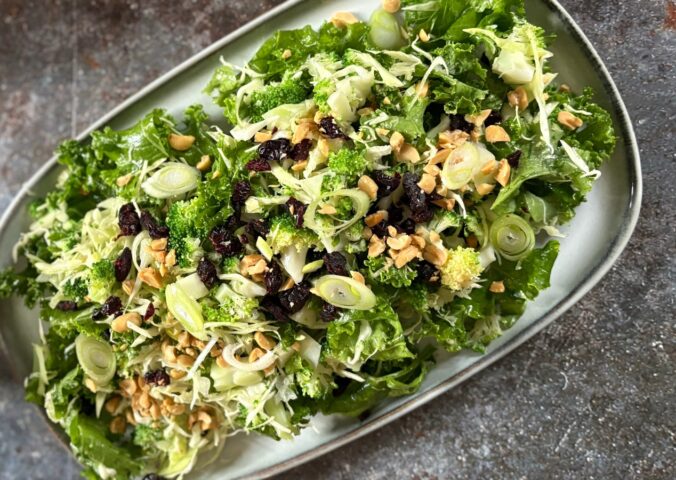 broccoli salad with kale, cabbage, dried cranberries, and peanuts