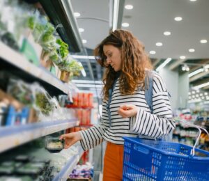 Photo shows a woman shopping and holding a basket. Dutch shoppers could save up to 30 percent on groceries by buying plant-based, according to a new price analysis