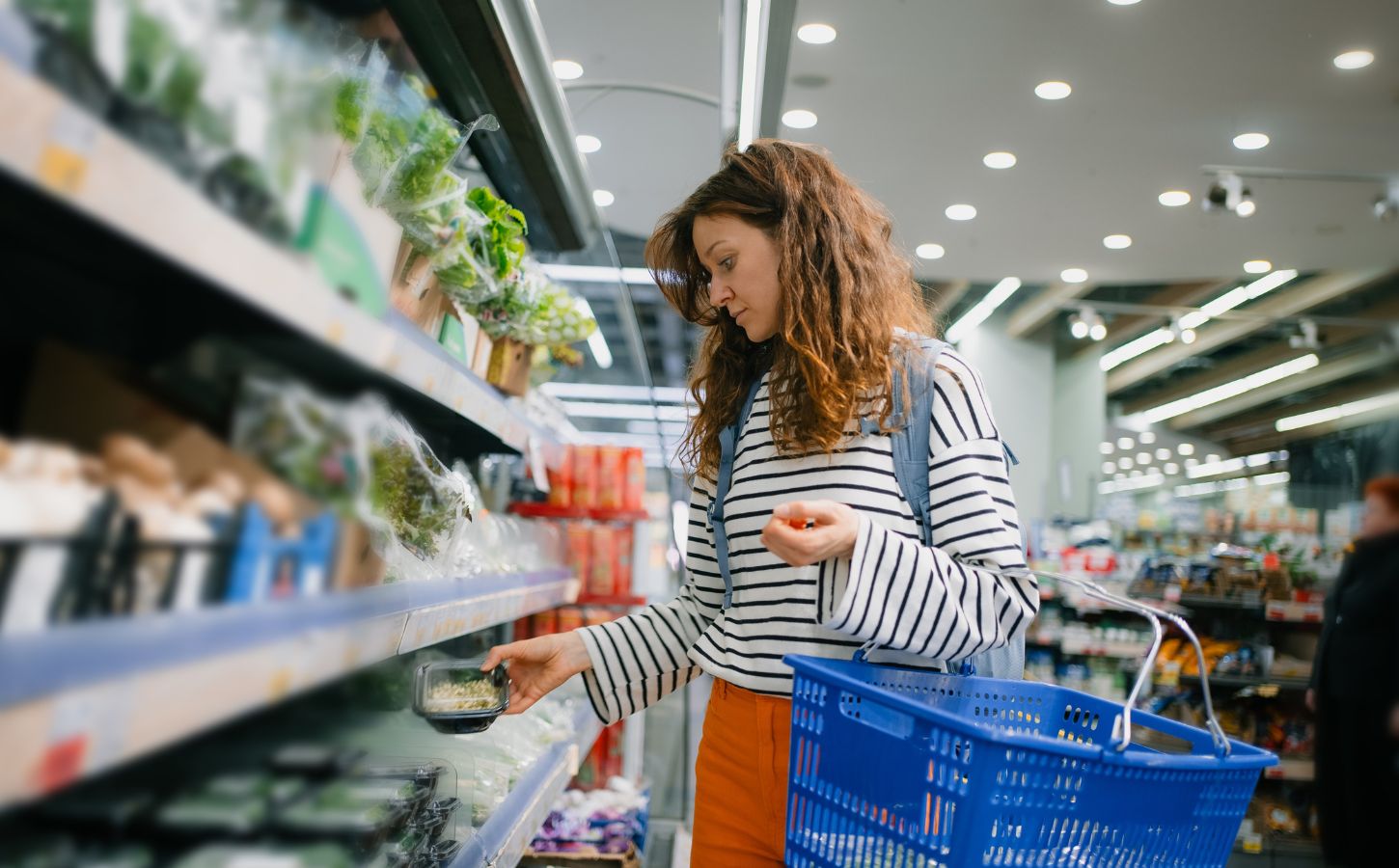 Photo shows a woman shopping and holding a basket. Dutch shoppers could save up to 30 percent on groceries by buying plant-based, according to a new price analysis