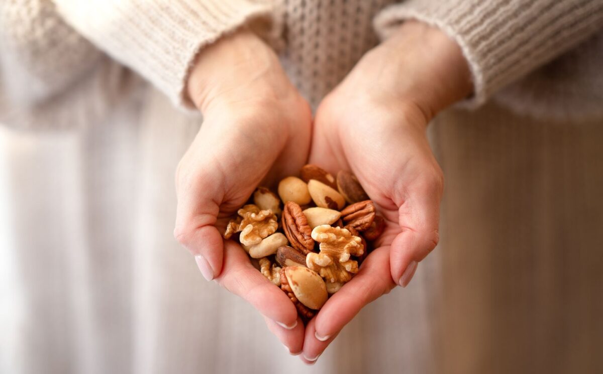 Photo shows someone using two hands to cup a selection of nuts. A new study has found that eating just one handful of nuts per day can reduce the risk of developing high blood pressure by 20 percent