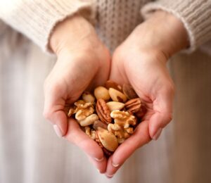Photo shows someone using two hands to cup a selection of nuts. A new study has found that eating just one handful of nuts per day can reduce the risk of developing high blood pressure by 20 percent