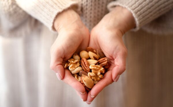 Photo shows someone using two hands to cup a selection of nuts. A new study has found that eating just one handful of nuts per day can reduce the risk of developing high blood pressure by 20 percent