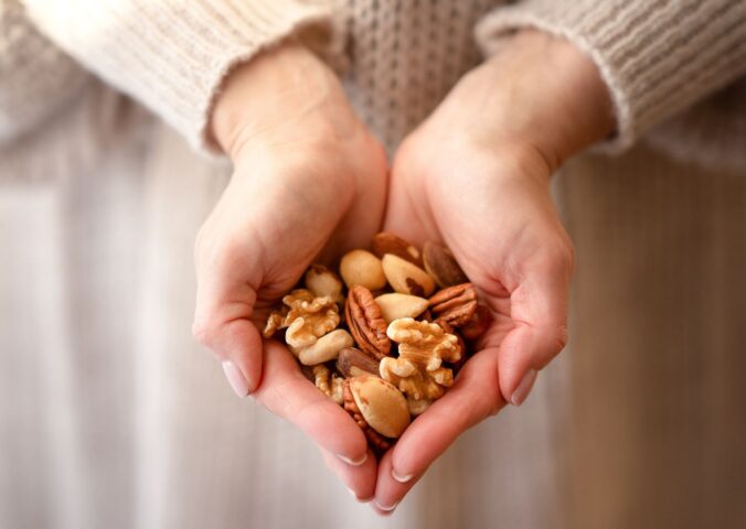 Photo shows someone using two hands to cup a selection of nuts. A new study has found that eating just one handful of nuts per day can reduce the risk of developing high blood pressure by 20 percent