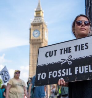 Photo shows a young woman protesting in London and holding a sign that reads: "Cut the ties to fossil fuels." The London Science Museum has cut ties with BP after decades of campaigning from activists, scientists, and schools