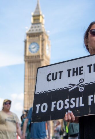 Photo shows a young woman protesting in London and holding a sign that reads: "Cut the ties to fossil fuels." The London Science Museum has cut ties with BP after decades of campaigning from activists, scientists, and schools