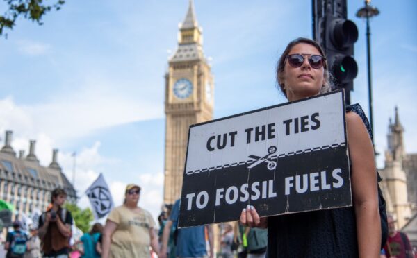 Photo shows a young woman protesting in London and holding a sign that reads: "Cut the ties to fossil fuels." The London Science Museum has cut ties with BP after decades of campaigning from activists, scientists, and schools