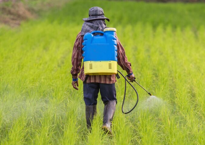 Photo shows a farmer spraying pesticides from a large container mounted on his back. A new study has found that pesticides poison nearly half of farmers worldwide every year