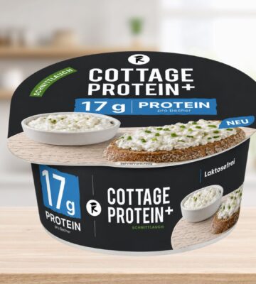 Photo shows the new vegan cottage cheese product, COTTAGE PROTEIN+, from Austrian food tech startup Revo Foods, against a stock kitchen background. The packaging is black, blue, and white. Revo Foods just launched a high-protein vegan cottage cheese made with fermented, upcycled apricot kernels