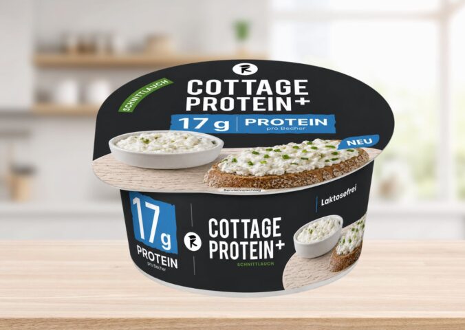 Photo shows the new vegan cottage cheese product, COTTAGE PROTEIN+, from Austrian food tech startup Revo Foods, against a stock kitchen background. The packaging is black, blue, and white. Revo Foods just launched a high-protein vegan cottage cheese made with fermented, upcycled apricot kernels