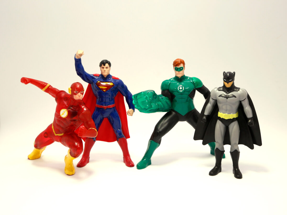 Photo shows a series of plastic toy superheroes, including the Flash, Superman, Green Lantern, and Batman. Aaron Pierre plays a vegan superhero in HBO’s Lanterns