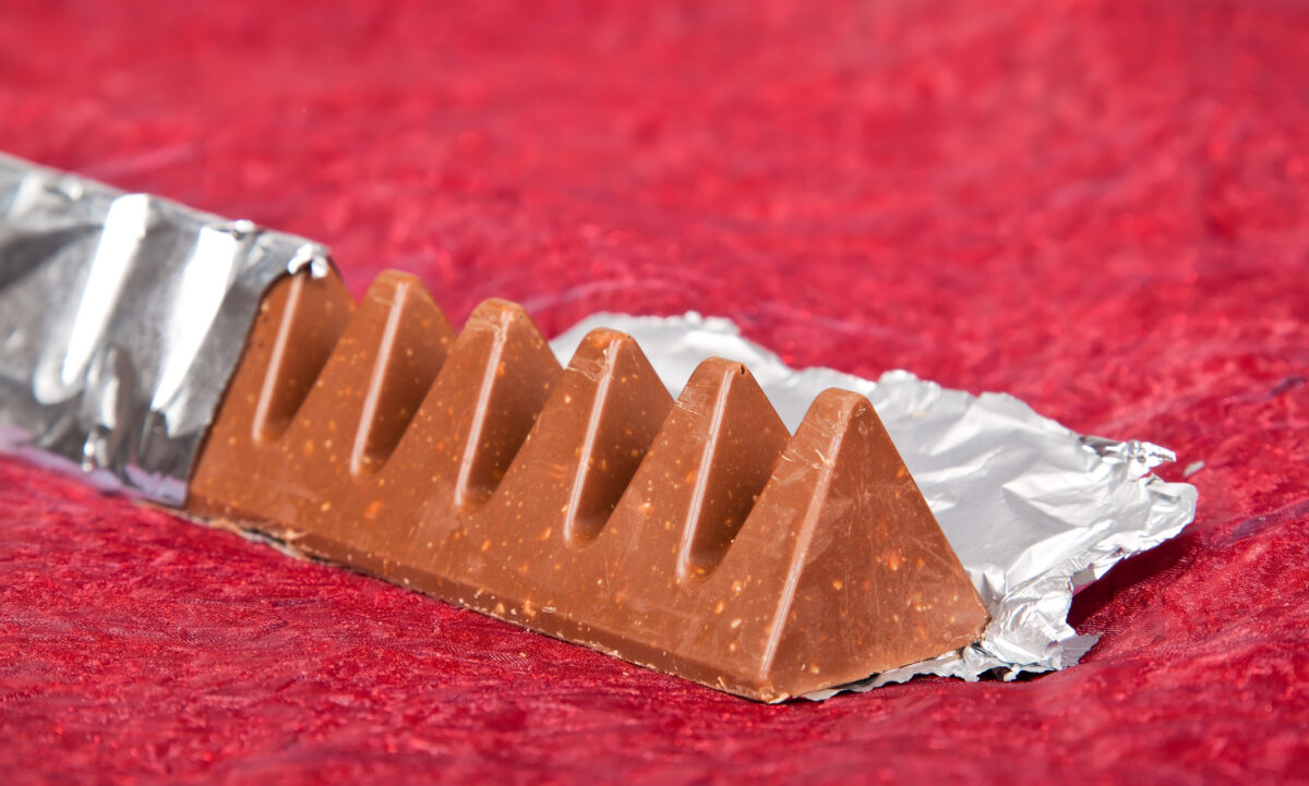 Photo shows a triangular, Toblerone style chocolate bar in a silver wrapper on a red carpet. Mondelēz, the maker of Toblerone, is suing Catherine’s Originals, a small vegan chocolate brand from the UK, over the shape of its O’Bar
