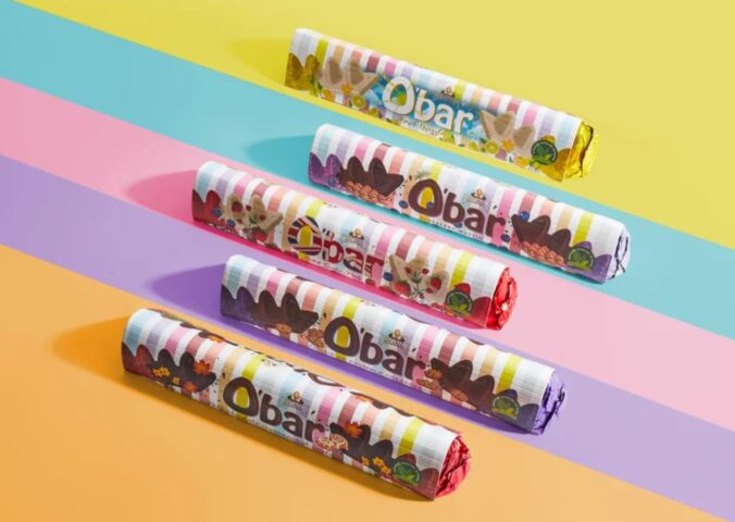 Photo shows a selection of O'Bar chocolate bars by Catherine Originals on a colorful digitally rendered backdrop. Mondelēz, the maker of Toblerone, is suing Catherine’s Originals, a small vegan chocolate brand from the UK, over the shape of its O’Bar