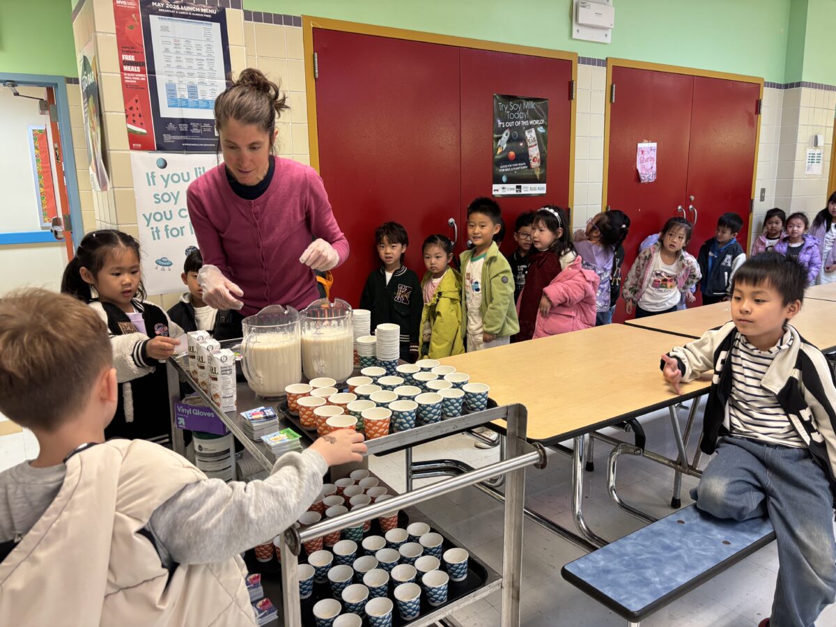 Photo shows school children queuing to receive their milk of choice at lunchtime