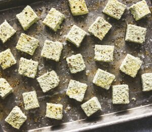 a tray of seasoned pumpkin seed tofu cubes for seed-filled recipes