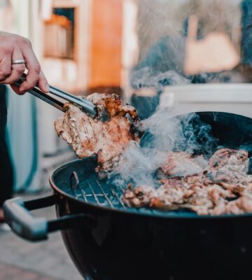Photo shows a man's hand as he BBQs red meat. Scientists analyzed the supposed benefits of carnivore diets and found the evidence base to be “thin.”