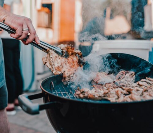Photo shows a man's hand as he BBQs red meat. Scientists analyzed the supposed benefits of carnivore diets and found the evidence base to be “thin.”