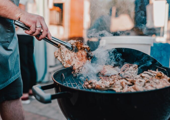 Photo shows a man's hand as he BBQs red meat. Scientists analyzed the supposed benefits of carnivore diets and found the evidence base to be “thin.”
