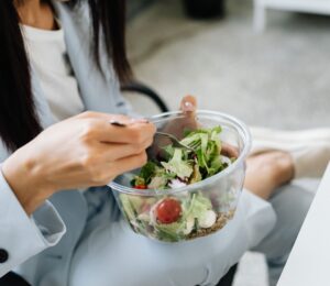 Swap meat for vegetables and cut chronic disease risk in the UK. Photo shows a woman eating a large bowl of fresh salad at her desk. According to a new study, reducing red and processed meat consumption in favor of vegetables and legumes could significantly reduce the number of chronic disease cases in the UK