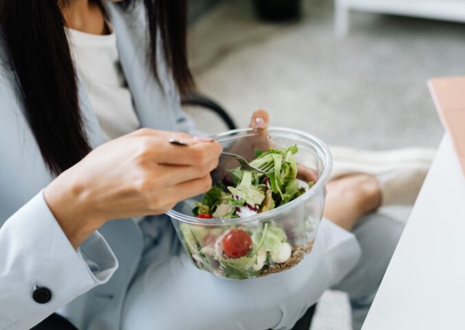 Swap meat for vegetables and cut chronic disease risk in the UK. Photo shows a woman eating a large bowl of fresh salad at her desk. According to a new study, reducing red and processed meat consumption in favor of vegetables and legumes could significantly reduce the number of chronic disease cases in the UK
